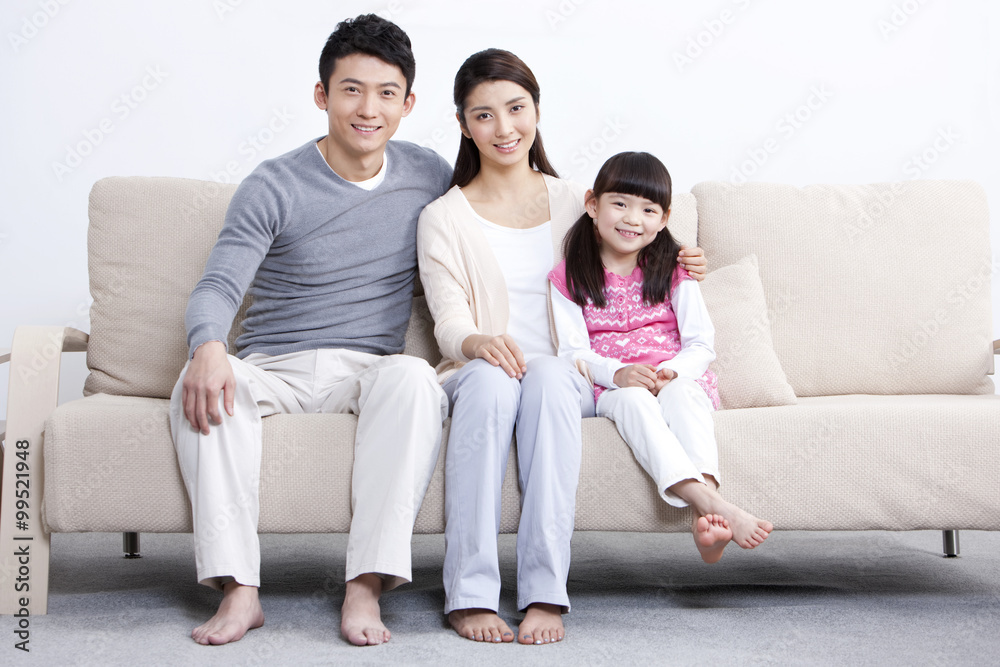 Portrait of happy young family sitting in sofa Portrait of happy young family sitting in sofa