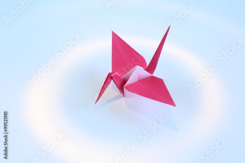 Red paper crane in spot light with white background