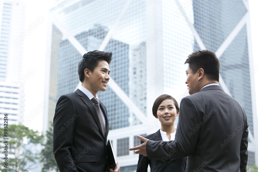 Cheerful business persons discussing with each other in Hong Kong Cheerful business persons discussing with each other in Hong Kong