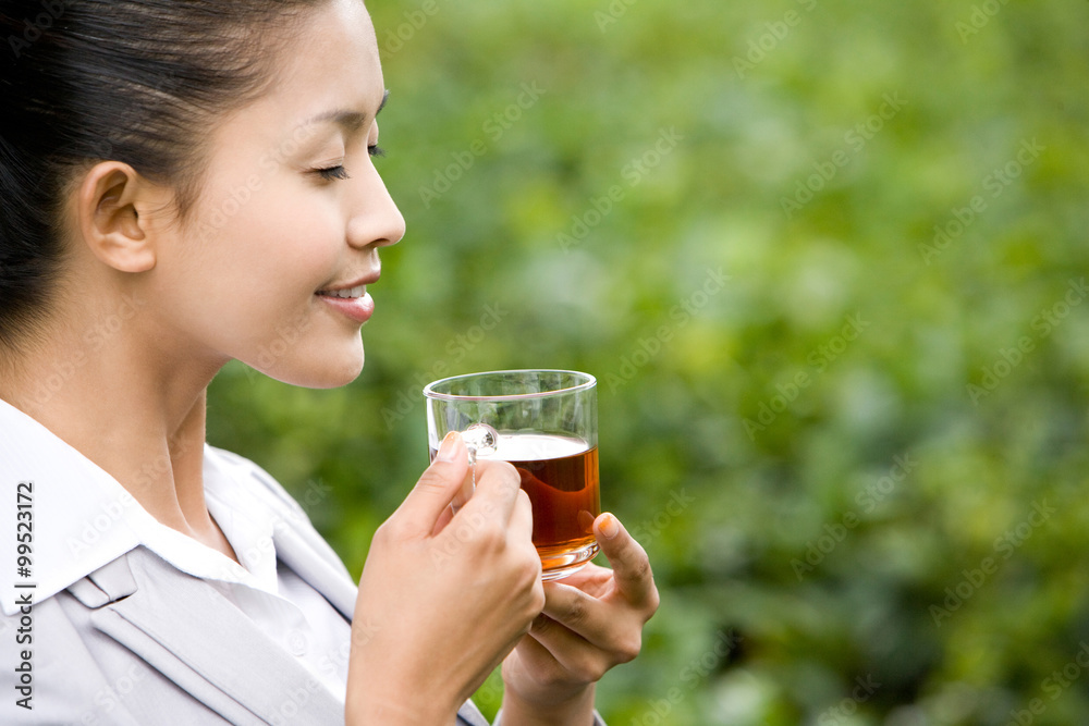 Young Businesswoman in Tea Field with Freshly Brewed Tea Young Businesswoman in Tea Field with Freshly Brewed Tea