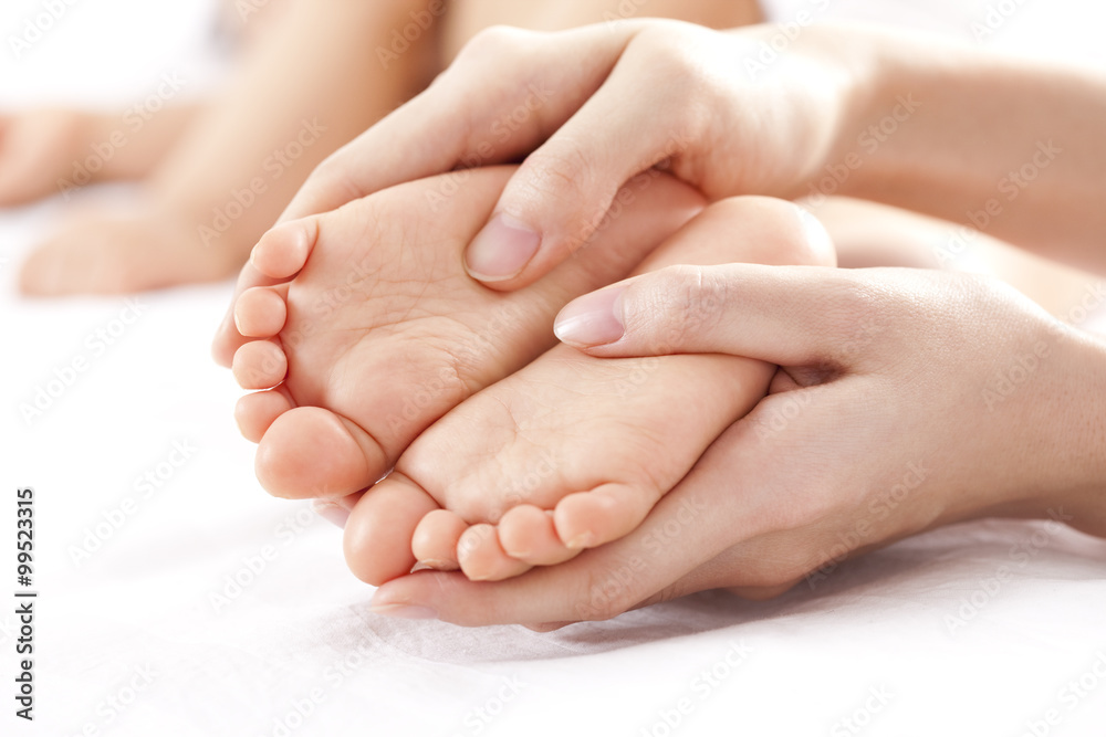 Mother holding sleeping baby's feet Mother holding sleeping baby's feet