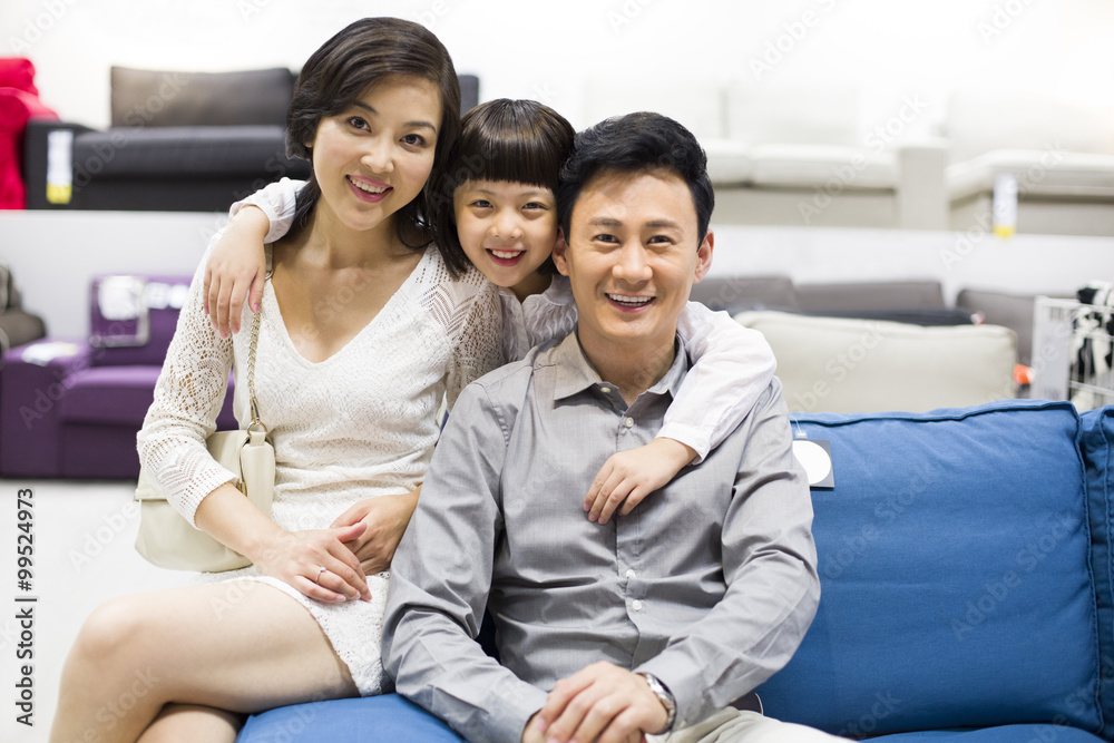 Cheerful family sitting in couch in furniture shop