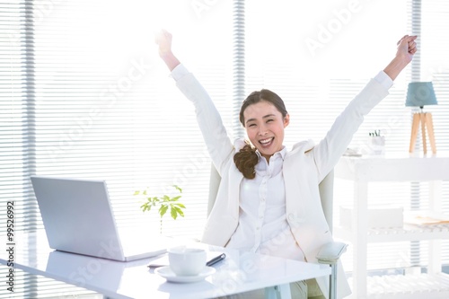 Businesswoman rejoicing with arms outstretched