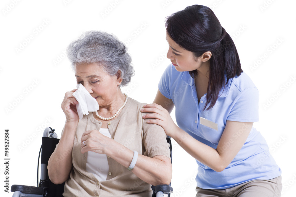 Female nursing worker comforting weeping senior woman Female nursing worker comforting weeping senior woman