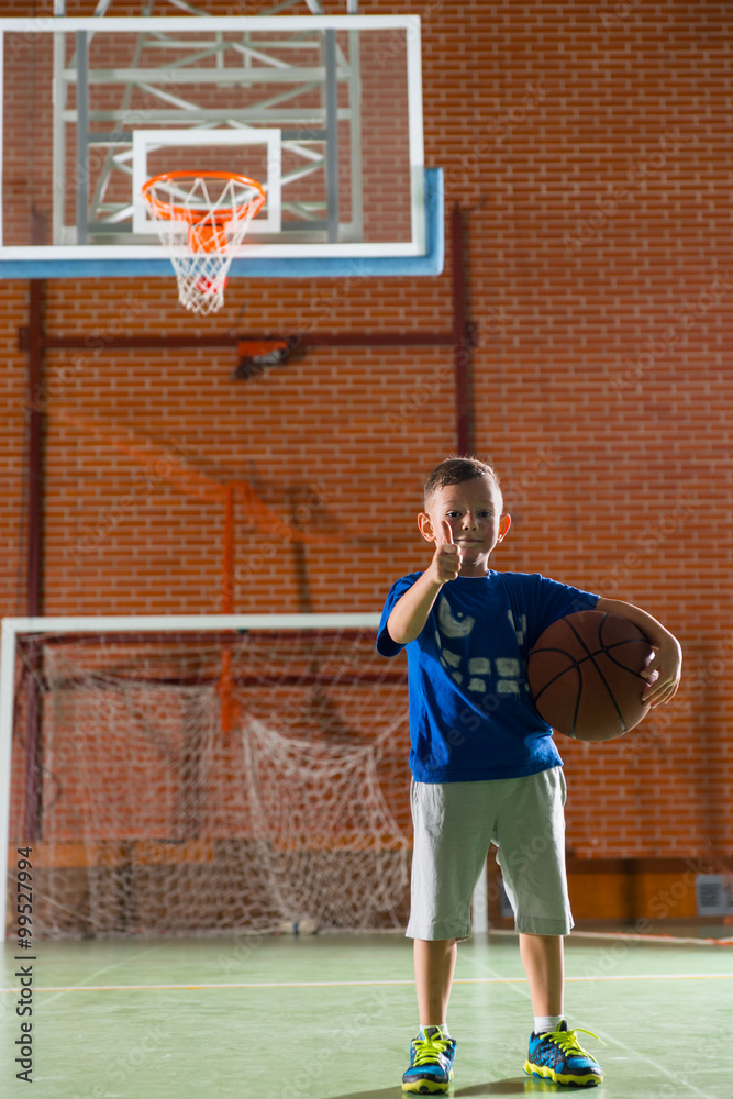 Fototapeta premium Proud little boy holding a basketball