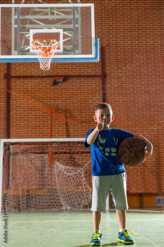 Proud little boy holding a basketball
