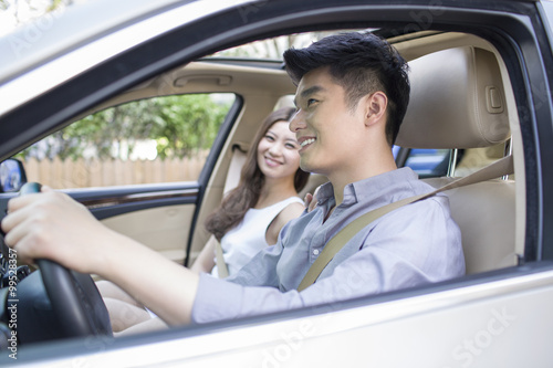 Happy young couple in a car