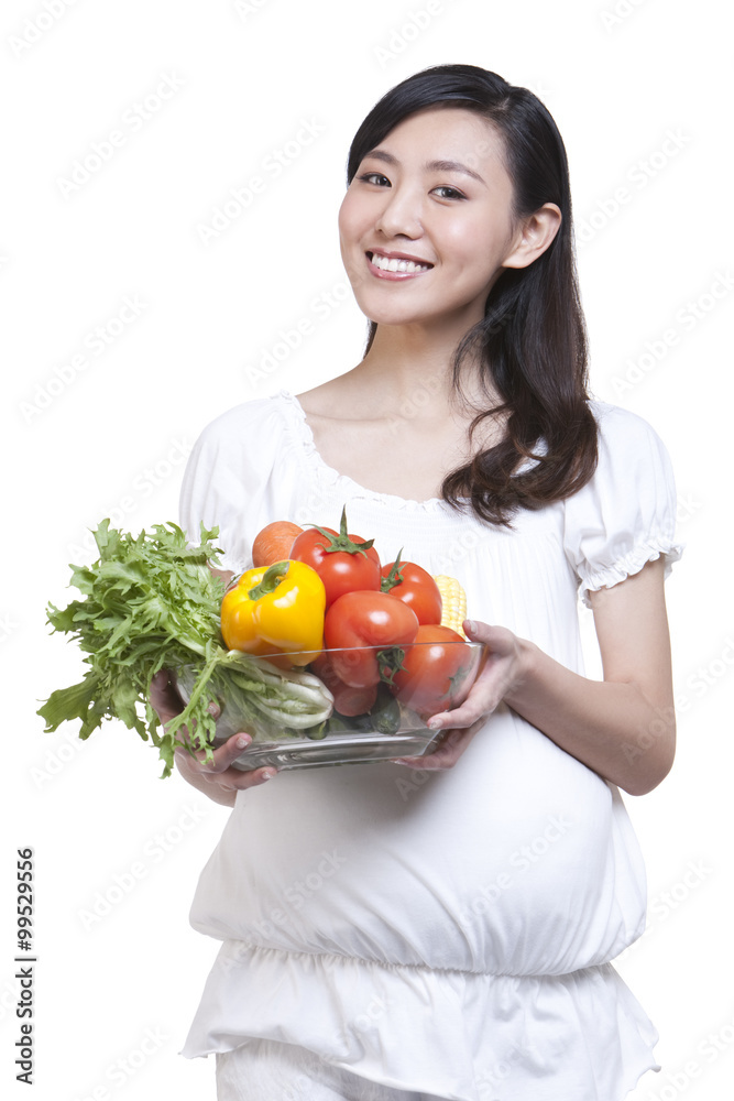 Pregnant woman holding a bowl of fresh vegetables Pregnant woman holding a bowl of fresh vegetables