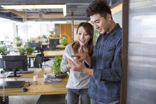 IT workers looking at smart phone in office