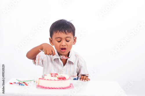 little asian boy eating birthday cake