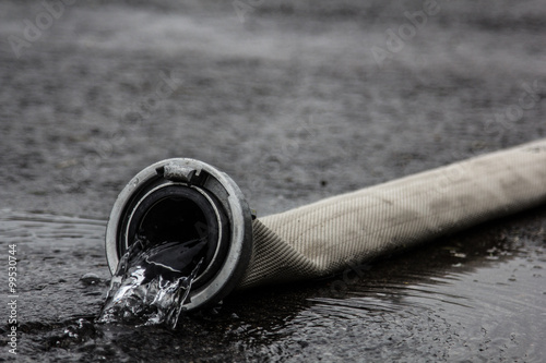 Feuerwehrschlauch mit auslaufenden Wasser