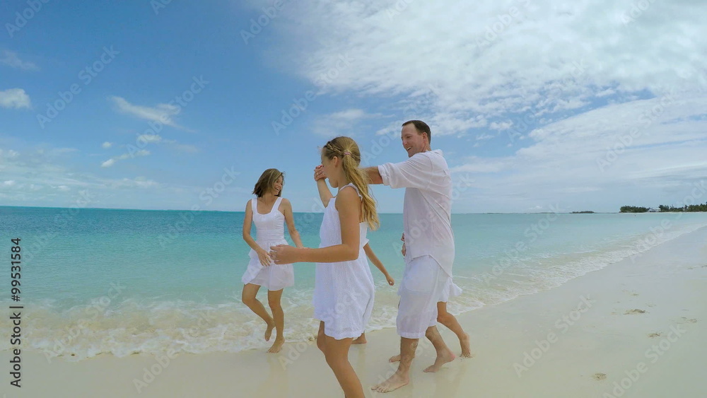 Caucasian family wearing white clothes playing barefoot on the beach Caucasian family wearing white clothes playing barefoot on the beach
