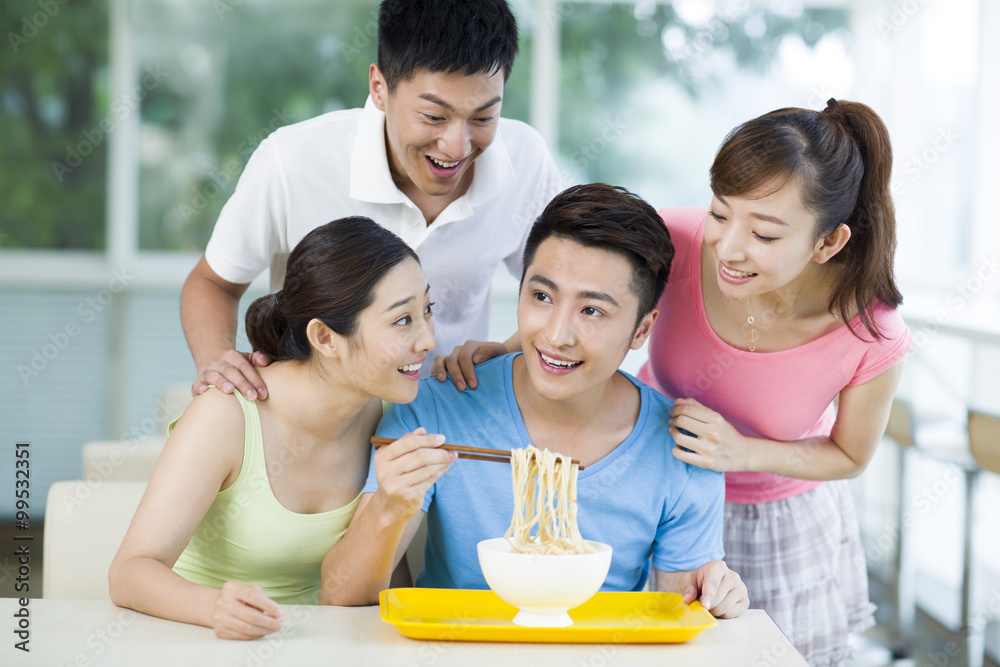 Young adults having noodles in restaurant