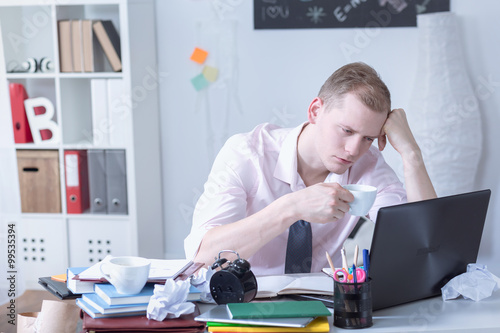 Overstudying man drinking coffee photo