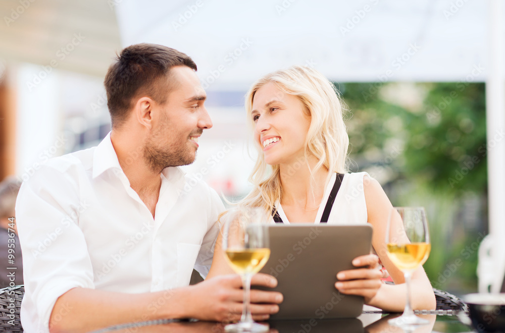 happy couple with tablet pc at restaurant lounge happy couple with tablet pc at restaurant lounge