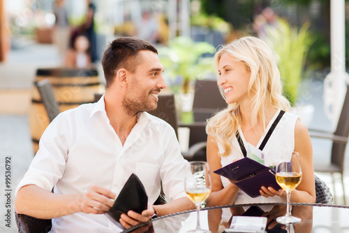 happy couple with wallet paying bill at restaurant photo