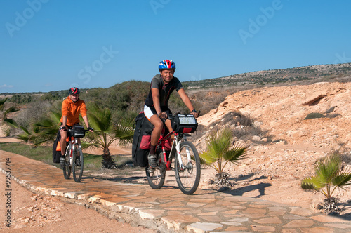 group of cyclists riding sandy beach mountain bike with backpack.