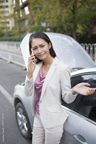 Car owner talking on the phone next to broken down car © Blue Jean Images