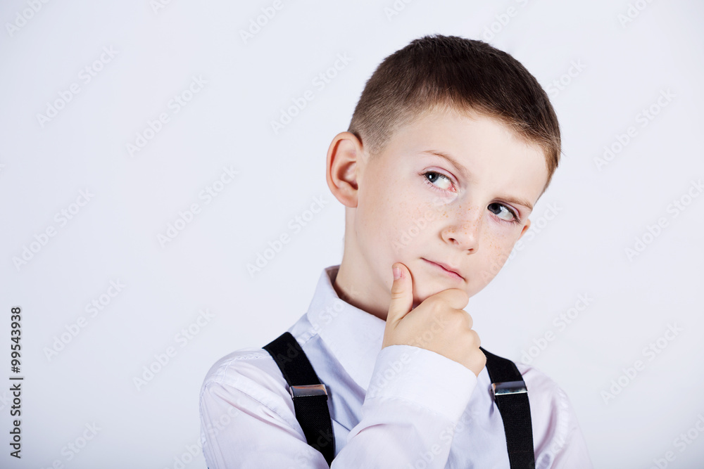 Thinking child-Portrait of a little boy thinking deeply about something with hand on chin looking to camera Thinking child-Portrait of a little boy thinking deeply about something with hand on chin looking to camera