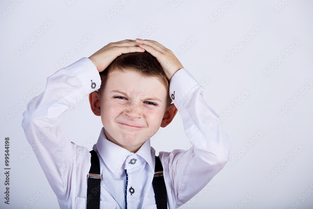 Stressed little boy having problems.Confused little boy with hand on his had over grey background.Stressed little boy having problems. Stressed little boy having problems.Confused little boy with hand on his had over grey background.Stressed little boy having problems.