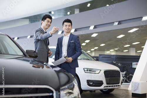 Young businessman choosing car in showroom © Blue Jean Images