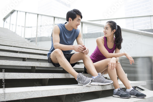 Young couple resting on the stairs after exercise