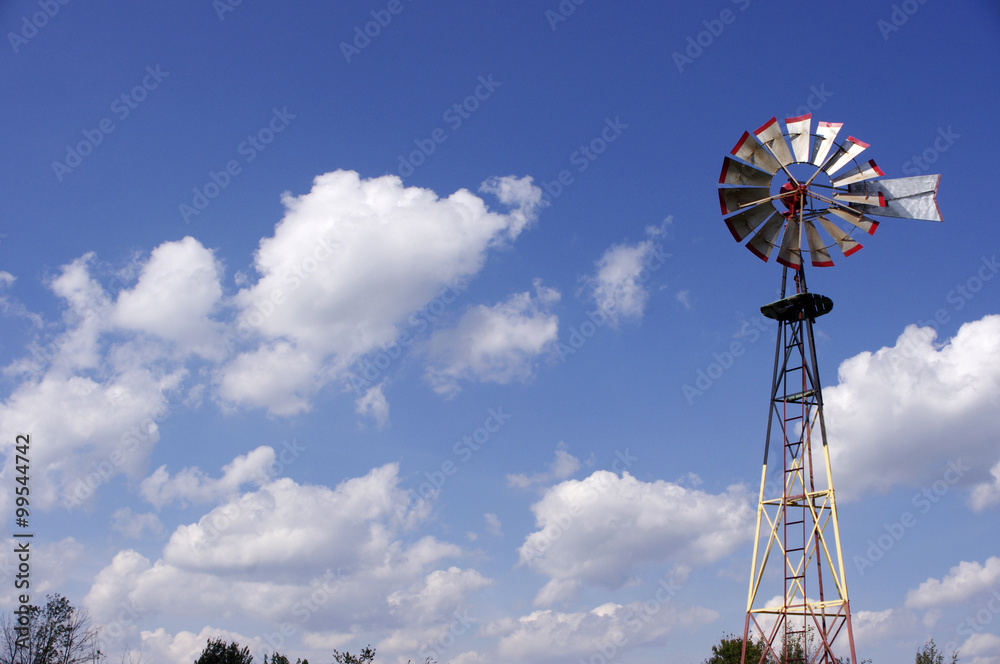 tall old metal windmill in blue sky tall old metal windmill in blue sky
