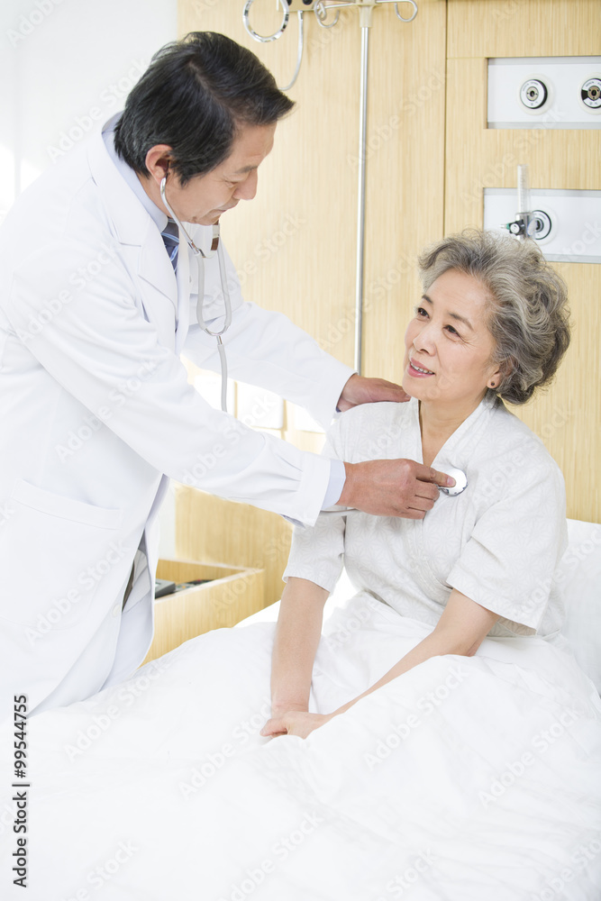 Doctor using stethoscope on patient in hospital Doctor using stethoscope on patient in hospital