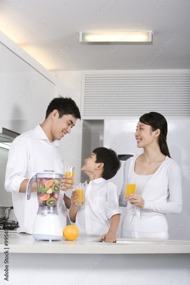 Family drinking  fresh fruit juice in kitchen