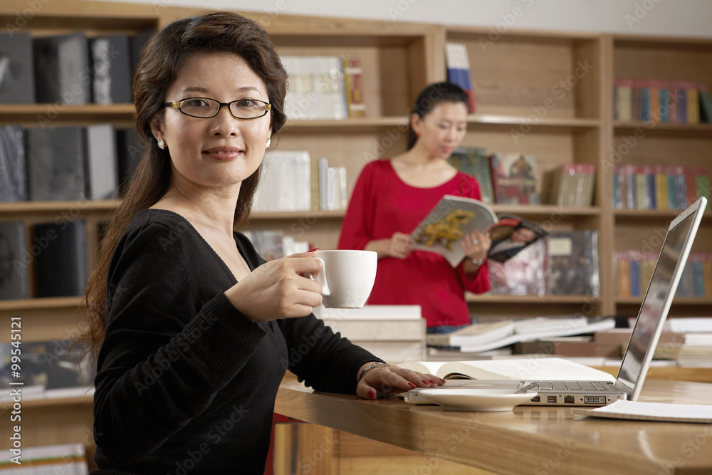 Woman Enjoying A Cup Of Tea In The Library Woman Enjoying A Cup Of Tea In The Library