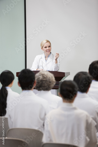 Female doctor giving speech in boardroom