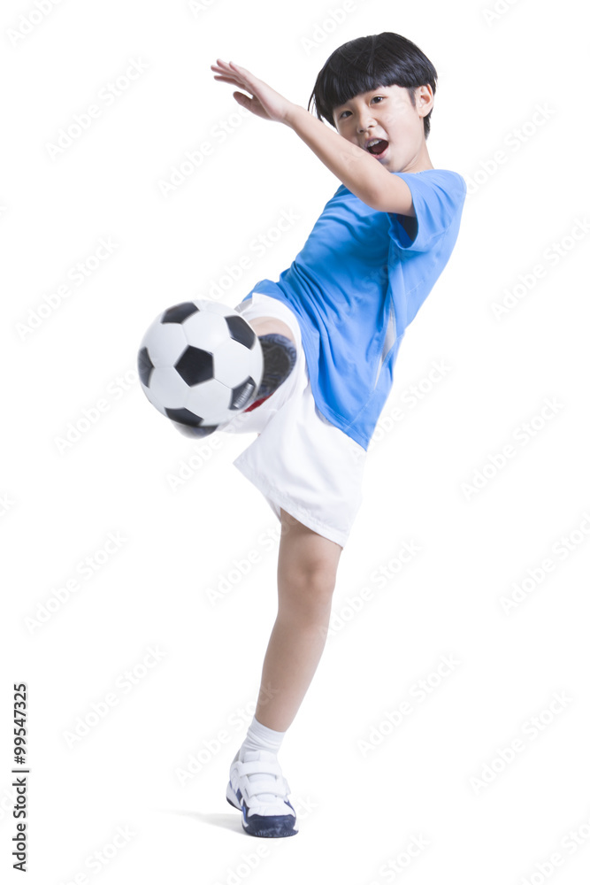 Cheerful boy kicking football Cheerful boy kicking football