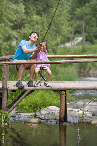 Portrait of father and daughter fishing