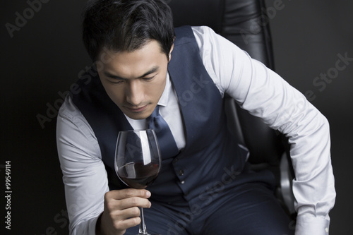 Confident businessman enjoying red wine