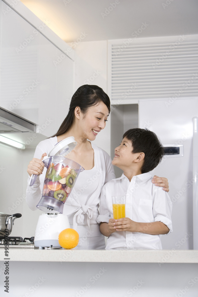 Mother and son making fresh fruit juice in kitchen Mother and son making fresh fruit juice in kitchen