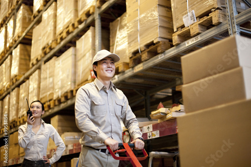 Male Chinese warehouse with Chinese businesswoman in the background