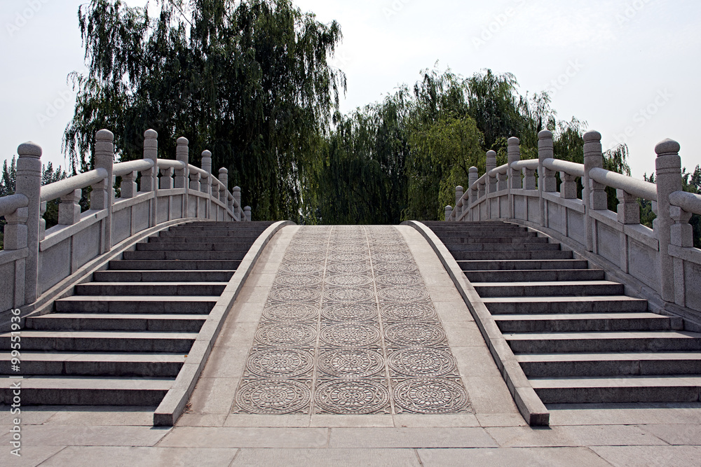Over an ornate stone bridge in a Beijing park.
