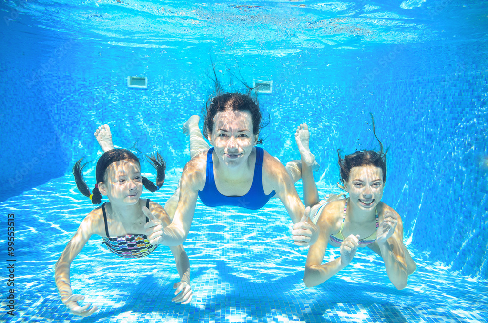 Family swim in pool underwater, happy active mother and children have fun under water