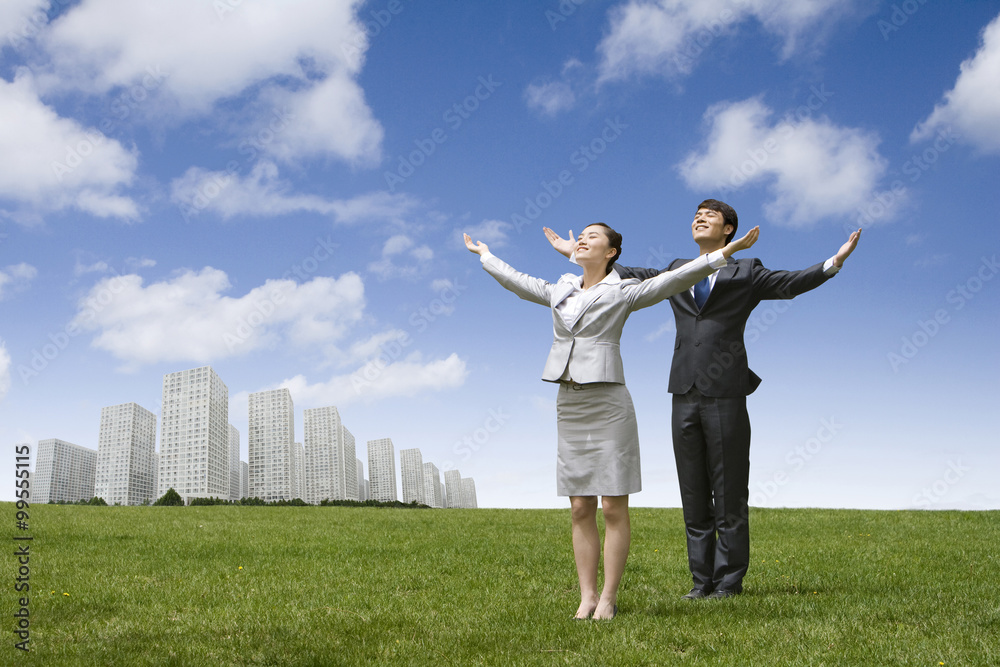 Businesspeople with their arms outstretched in an urban park Businesspeople with their arms outstretched in an urban park