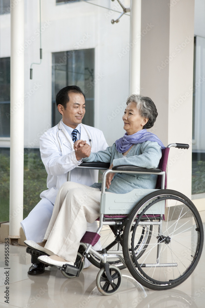 Doctor Comforts a Senior Woman in a Hospital Corridor