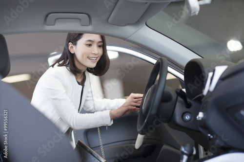 Young woman choosing car in showroom © Blue Jean Images