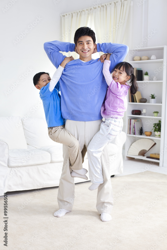 Fototapeta premium Chinese father with children hanging from his arms