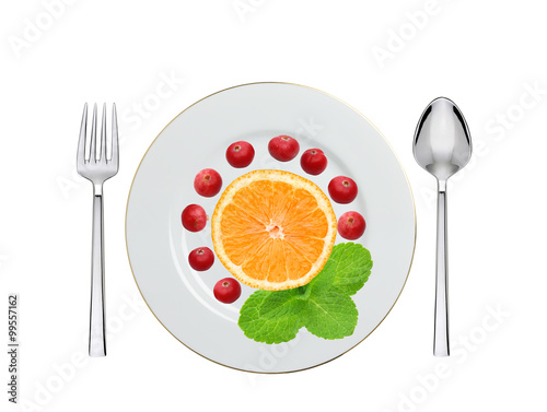 plate with cranberry, orange and mint herb, spoon and fork isola