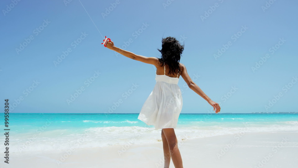 Barefoot African American girl on beach playing with kite Barefoot African American girl on beach playing with kite