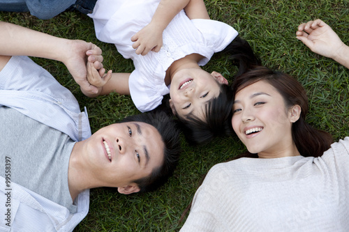 Young family lying on the grass