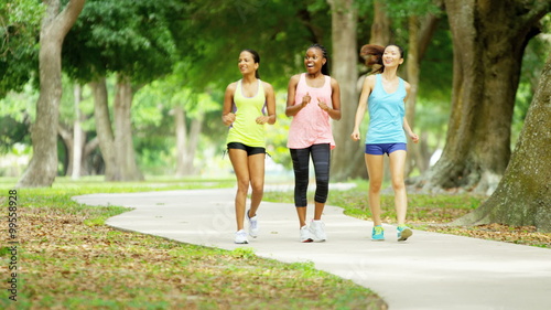 Young happy multi ethnic American girls power walking to keep healthy