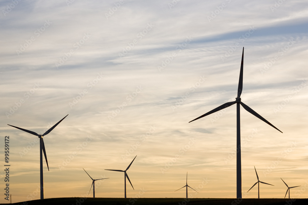 Fototapeta premium Silhouettes of wind turbines on sunset sky background