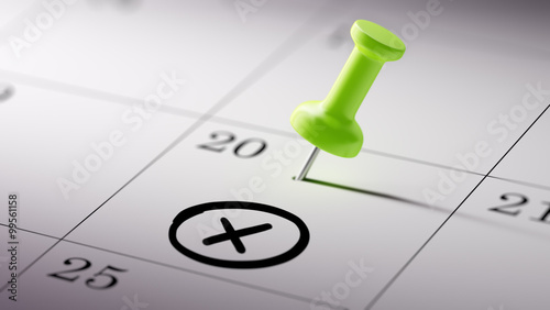 Concept image of a Calendar with a green push pin. Closeup shot
