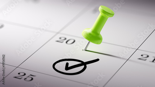 Concept image of a Calendar with a green push pin. Closeup shot