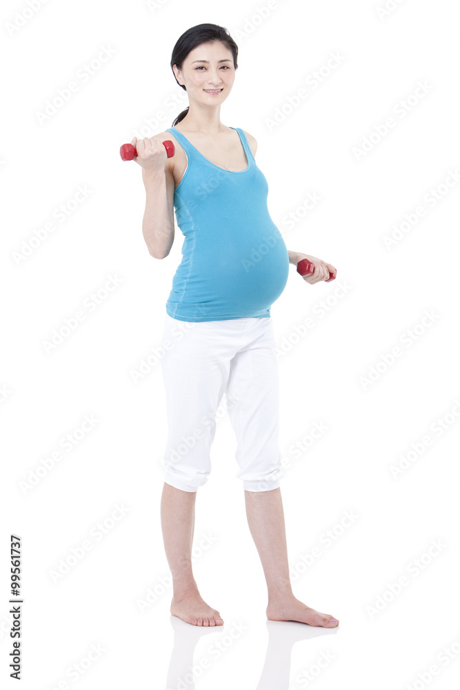 Young pregnant woman exercising with dumbbells Young pregnant woman exercising with dumbbells